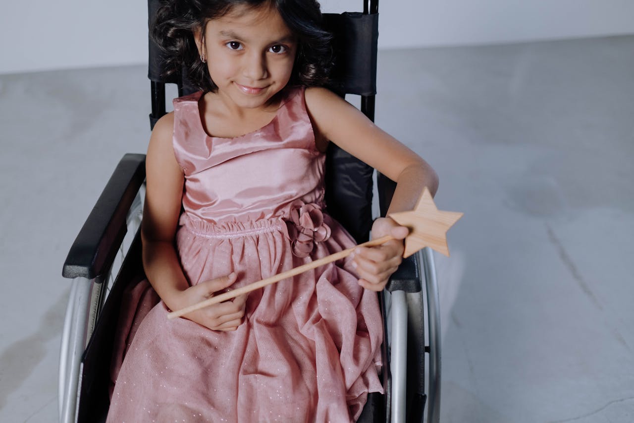 happy girl in a wheelchair with a wand